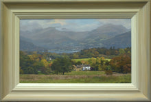 Load image into Gallery viewer, 10 x 17 inch landscape, with the white, sunlit High Wray Farm in the middle distance, with Windermere Lake in the distance and the blue distant mountains partly shrouded under cloud. Lots of Autumn-coloured trees abounding throughout. Shows the frame, with its off-white inner, gradating to a beige/grey outer edge.
