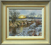 A bend in the River Welland at Duddington, with snow on the foreground bank and a fierce sun breaking on the skyline of distant trees, and a Hawthorn bush on the far riverbank on the left. Photo shows the frame with an off-white inner slip, a gold ribbed line then a gradated frame with a buff inner edge and a grey outer edge.