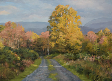 10 x 14 inch oil of a track leading through brilliant, Autumn coloured trees, with a bright yellow Birch tree right of centre, with the blue fells in the distance.